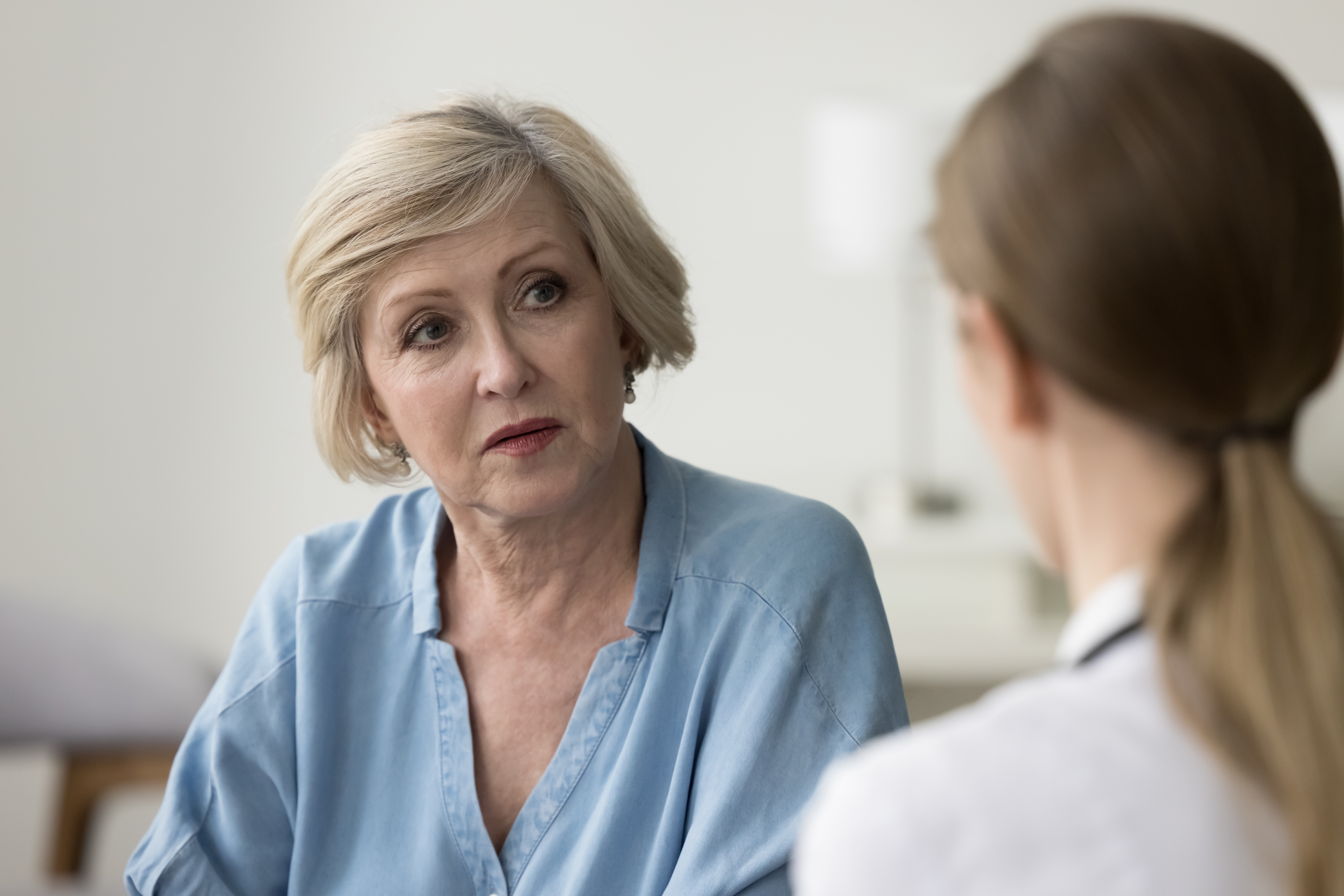 Older patient in conversation with a clinician during a medical consultation