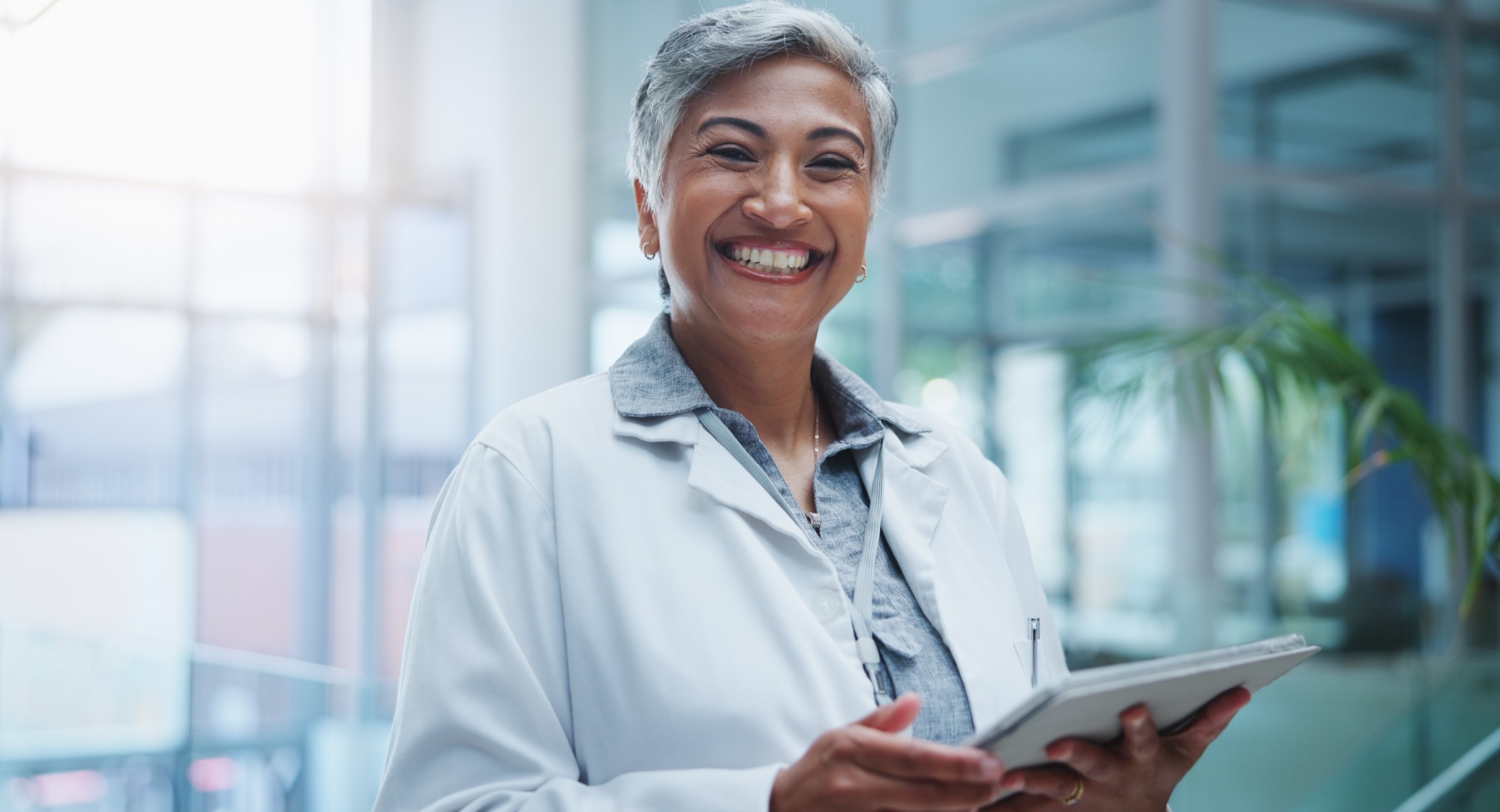Physician holding a tablet in a bright modern clinic